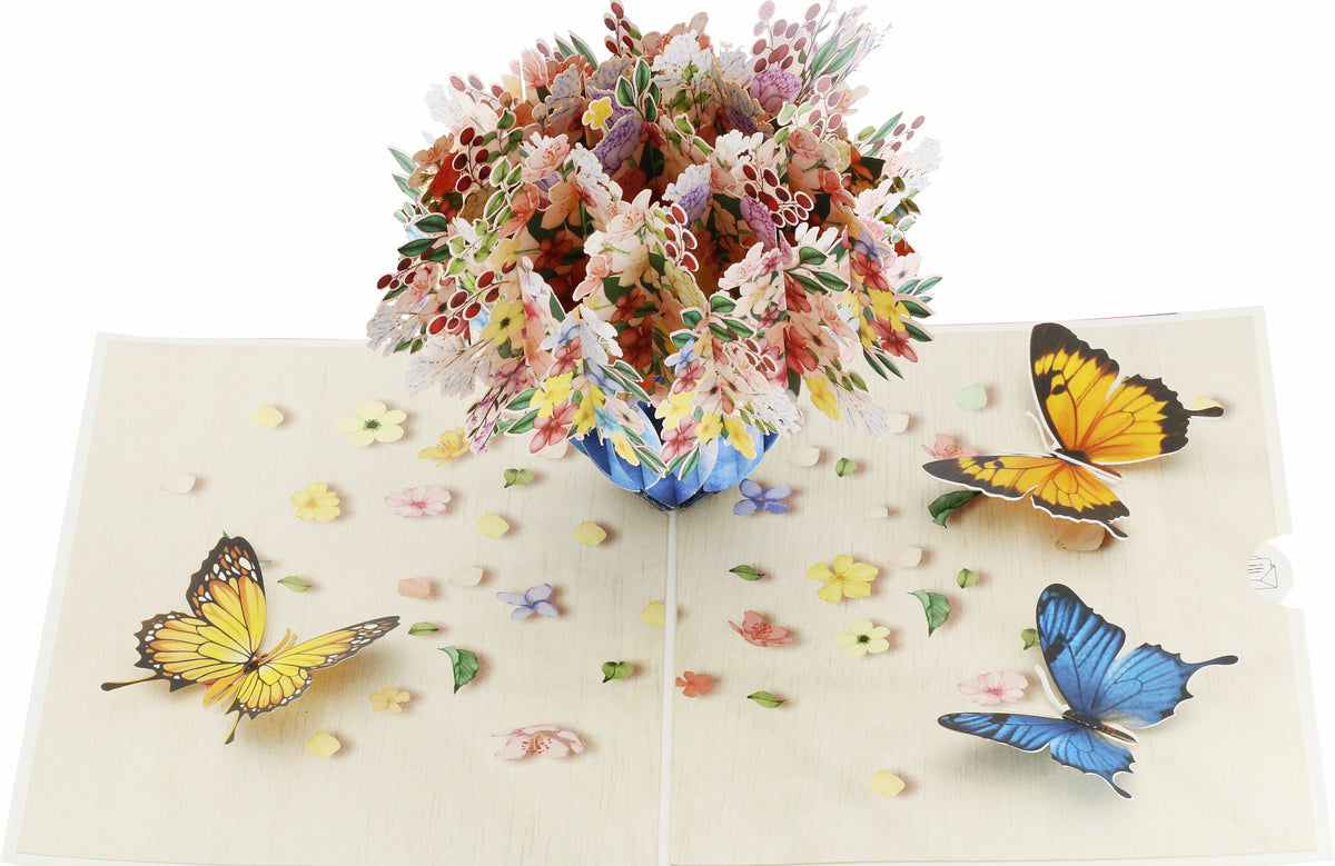 Aufgeklappte Pop-up-Karte mit buntem Blumenstrauß und Schmetterlingen, seitlich fotografiert.