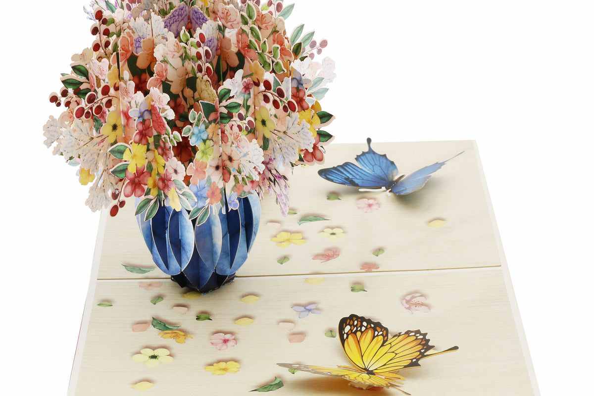 Nahaufnahme der aufgeklappten Pop-up-Karte mit üppigem Blumenstrauß in blauer Vase.