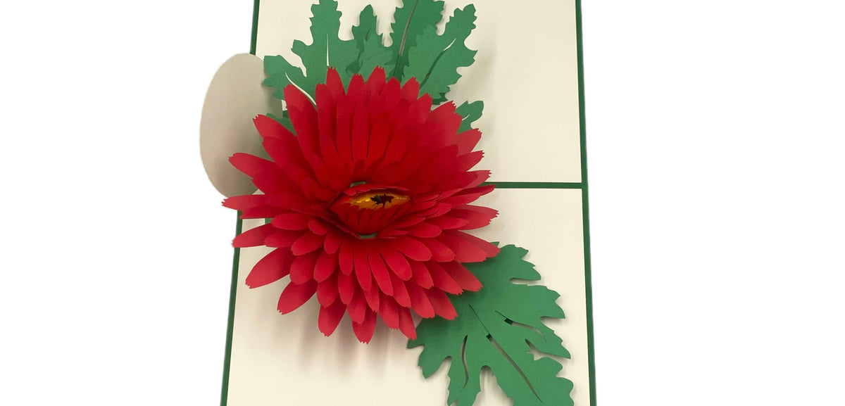 Aufgeklappte Pop-up-Karte mit roter Chrysantheme, schräg von oben fotografiert.
