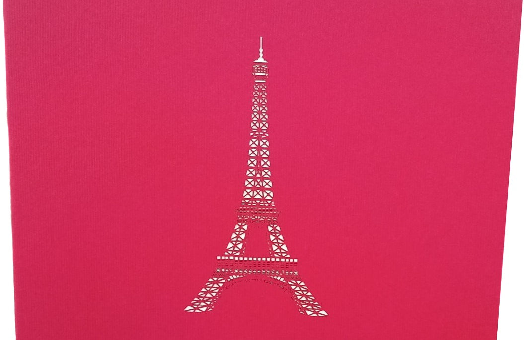 Pinke Kartenvorderseite mit dem Eiffelturm als Scherenschnitt.