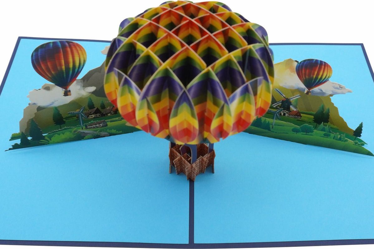 Nahaufnahme der aufgeklappten Pop-up-Karte mit buntem Heißluftballon über Bergen und Wolken.