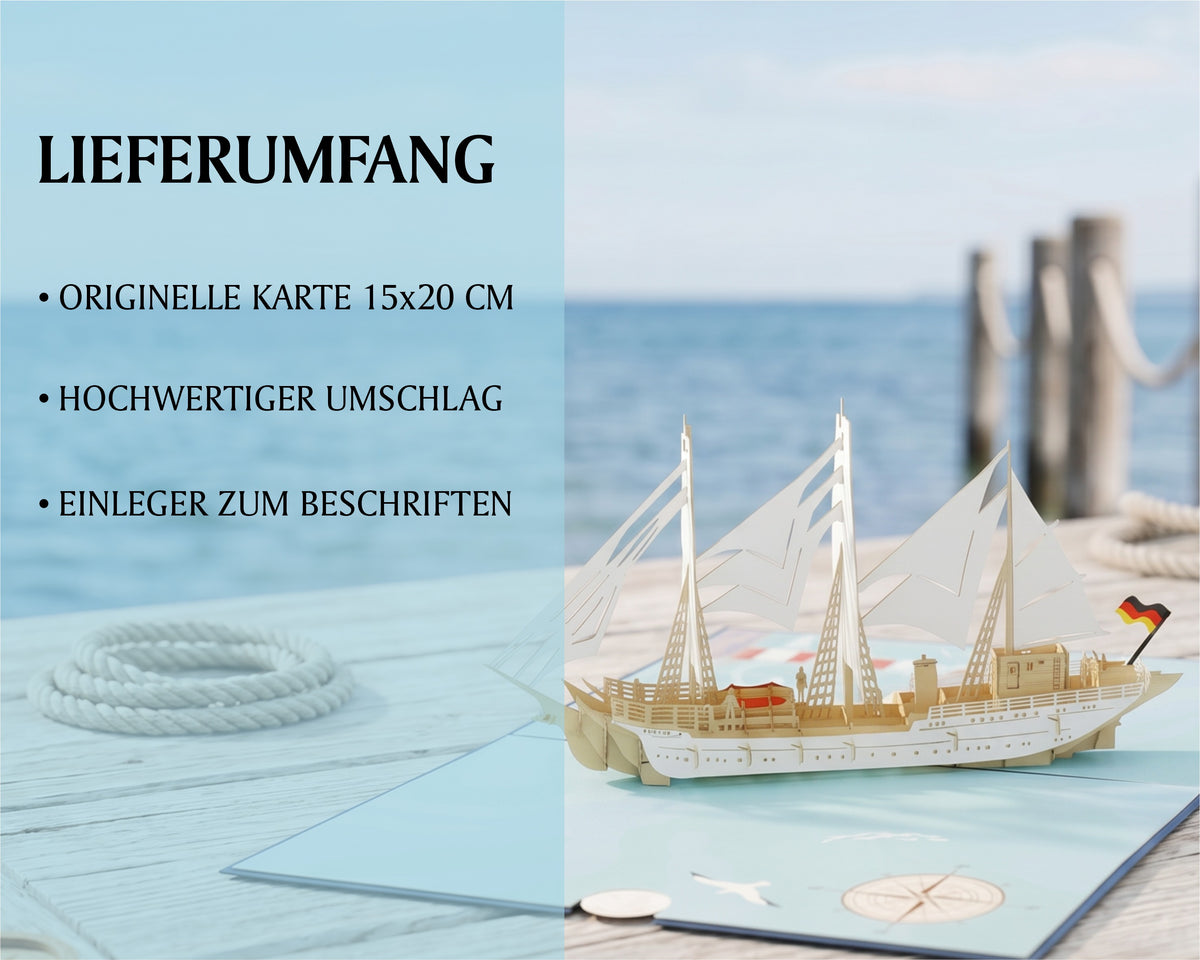 Geöffnete Pop-up-Karte mit einem aufklappbaren Gorch Fock Segelschiff in der Mitte, Kompassrose und Leuchtturm auf der Kartenfläche. Im Hintergrund ein Steg am Meer.