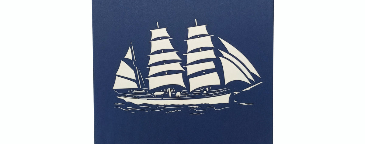 Blaue Karte mit Gorch Fock Schiff mit drei Segelmasten als ausgeschnittenes Motiv im Scherenschnitt Stil.