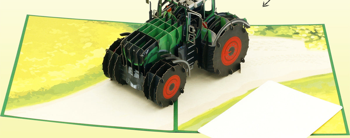 Aufgeklappte Pop-up-Karte mit detailreichem Traktor Modell aus Papier auf einem Feldweg und einem passenden Einleger zum Beschriften