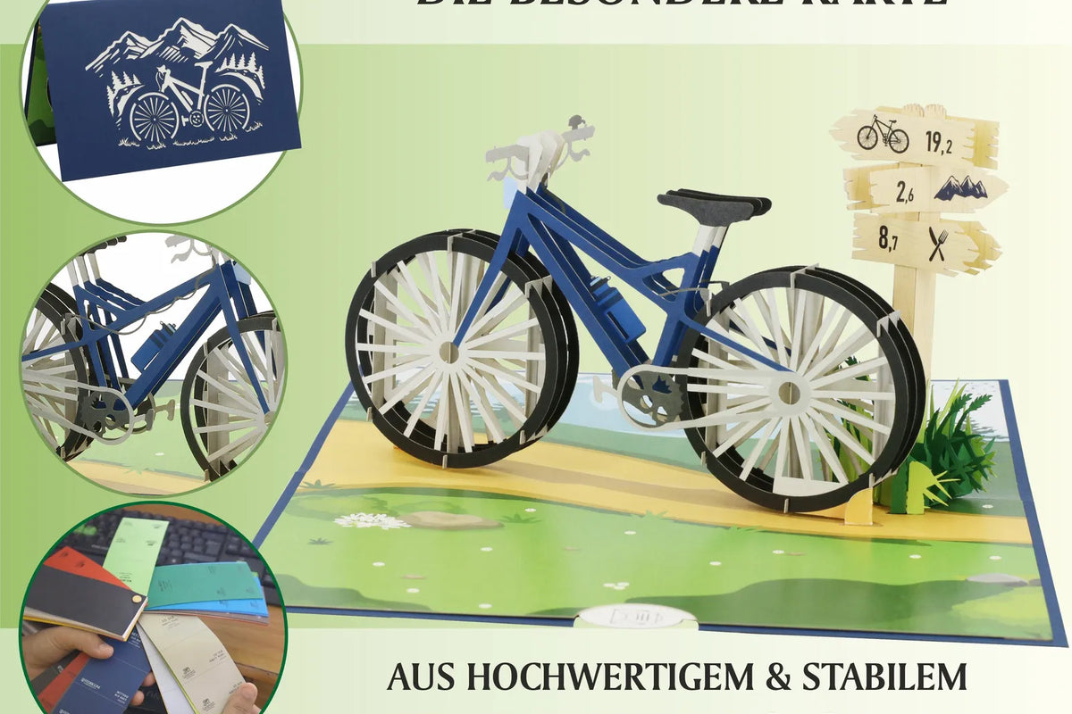 Aufgeklappte Pop-up-Karte mit detailreichem Fahrradmodell aus Papier, daneben Wegweiser und Wiese, oben links geschlossene Karte mit Fahrradsilhouette.