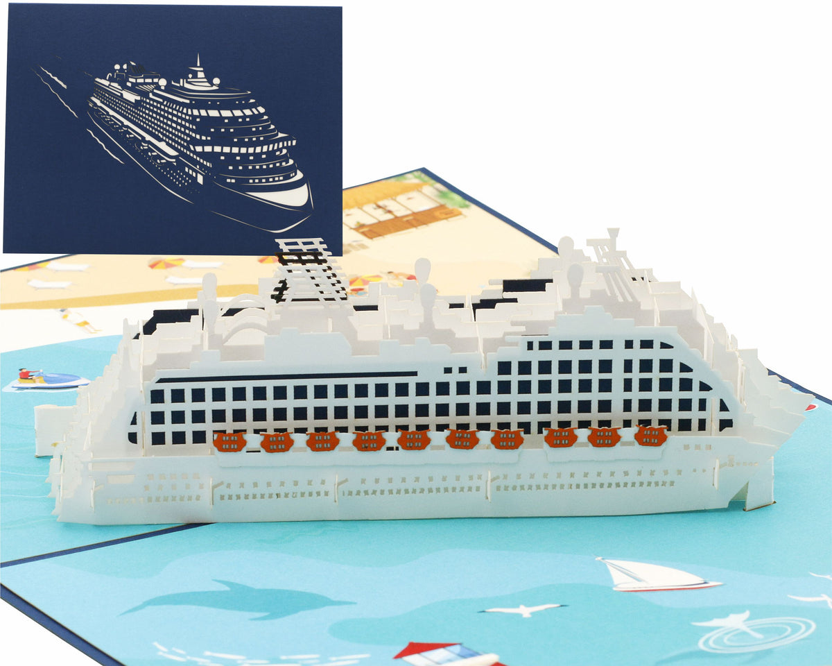 Aufgeklappte Pop-up-Karte mit einem weißen Kreuzfahrtschiff auf türkisem Meer, dahinter die blaue Kartenvorderseite mit Schiffs-Scherenschnitt.
