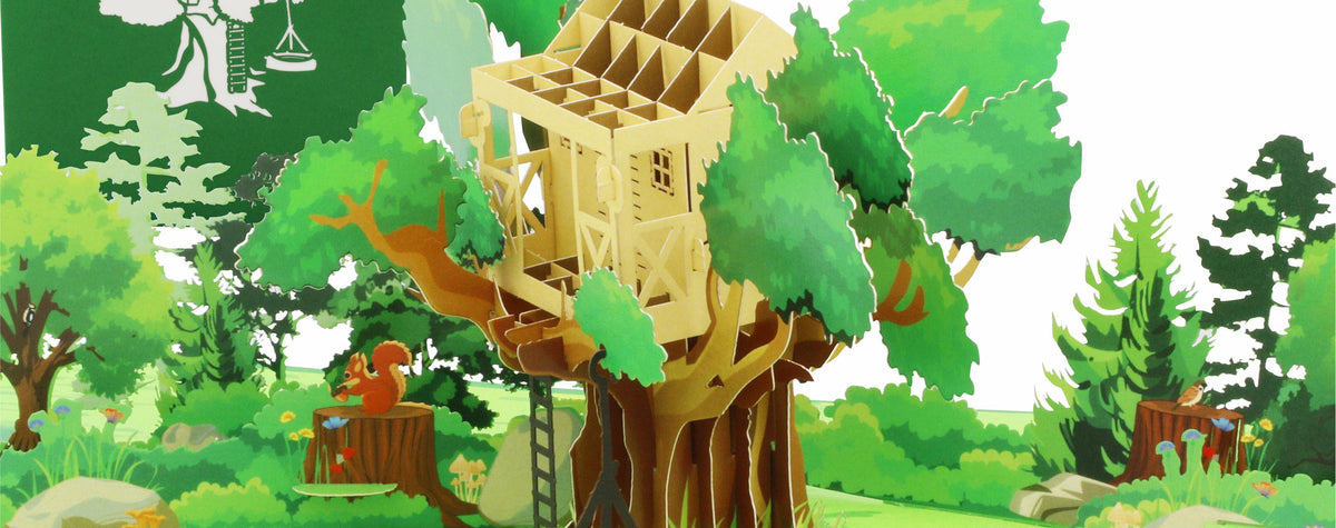 Aufgeklappte Pop-up-Karte mit einem Baumhaus in einem grünen Wald mit Reifenschaukel, dahinter die grüne Kartenvorderseite mit Baumhaus-Scherenschnitt.