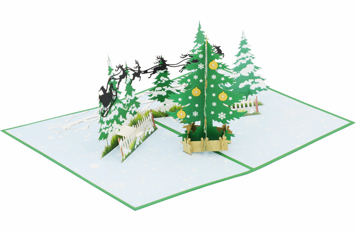 Aufgeklappte Pop-up-Karte mit Winterwald und Rentierschlitten, von schräg oben fotografiert.