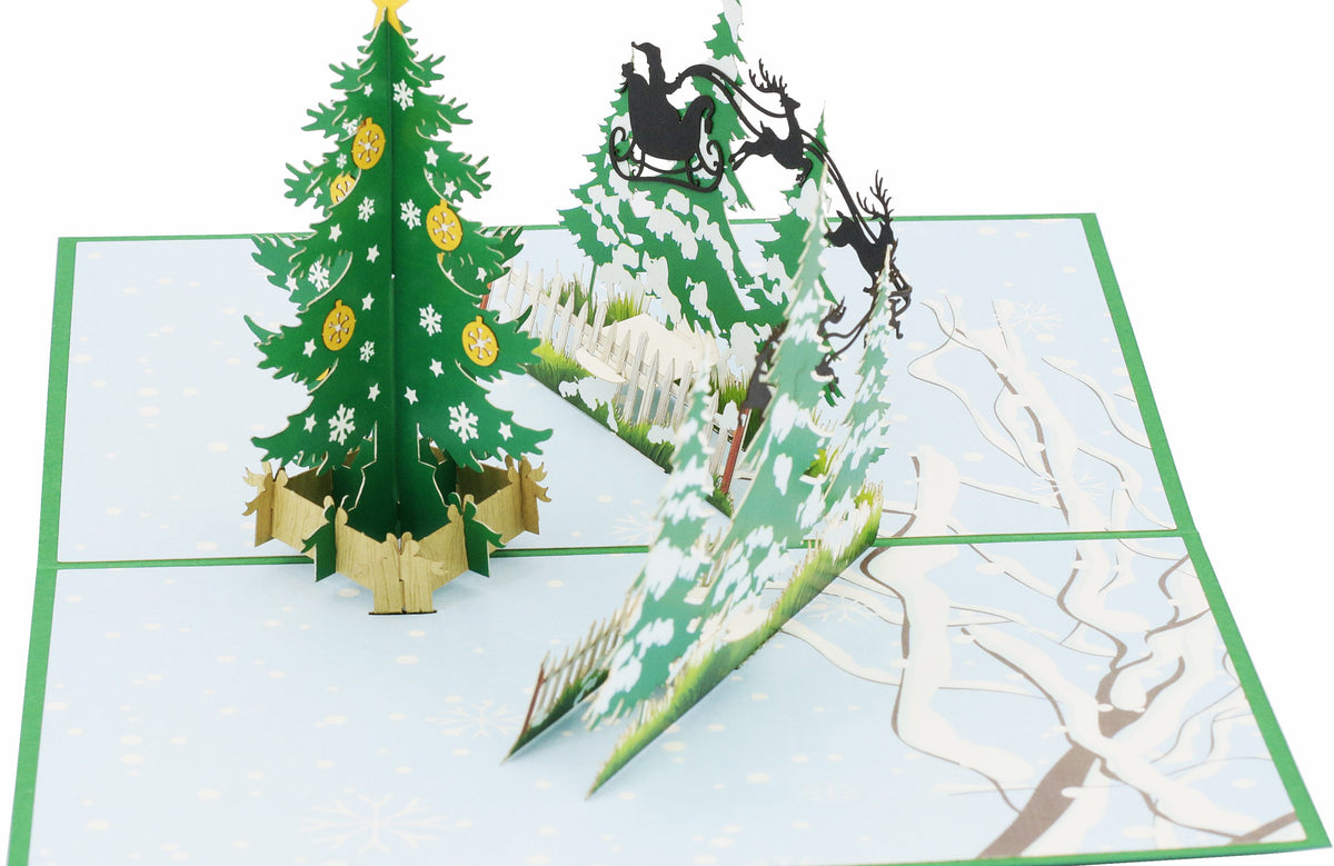 Nahaufnahme der aufgeklappten Pop-up-Karte mit geschmücktem Tannenbaum und Rentierschlitten.