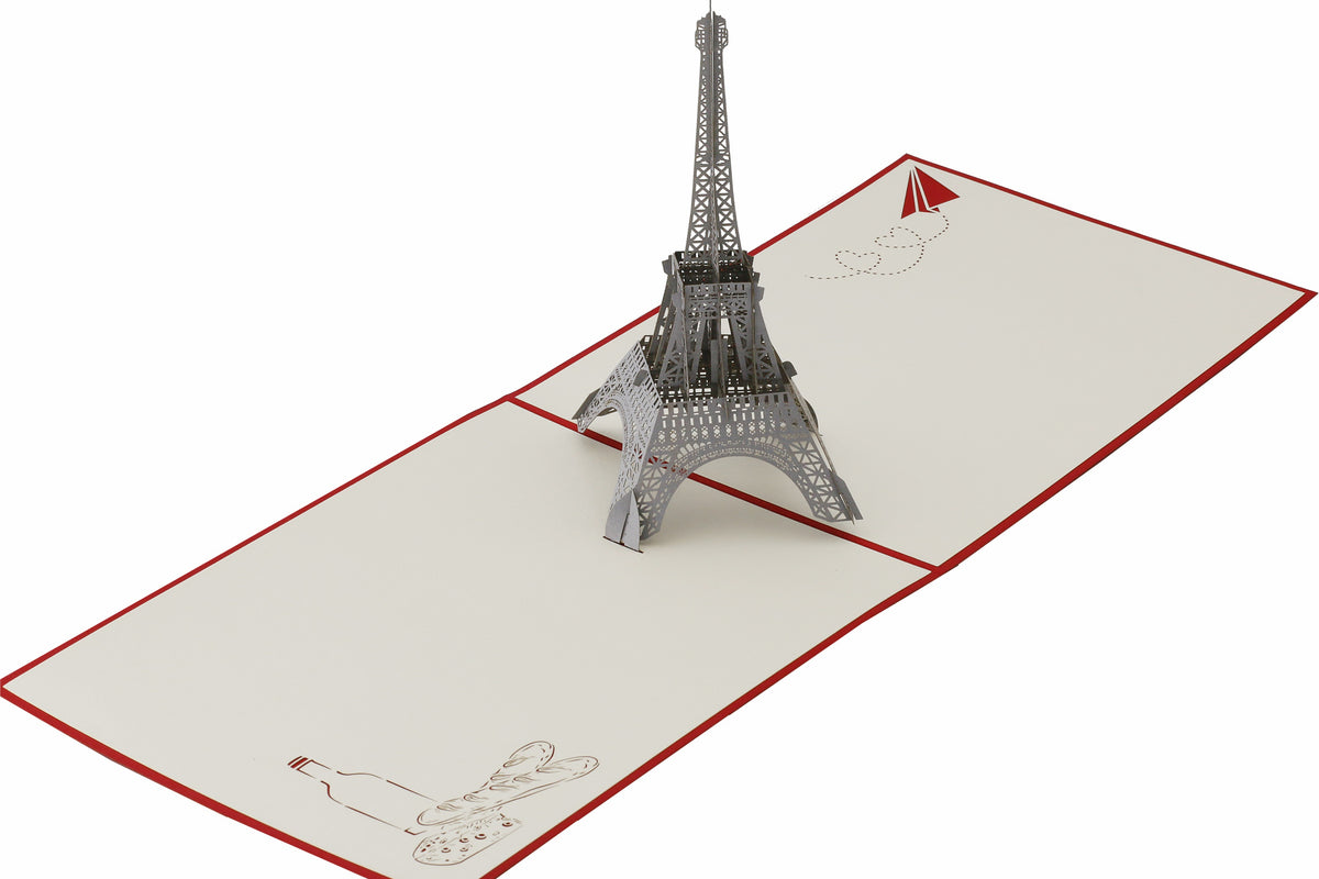 Aufgeklappte Pop-up-Karte mit Eiffelturm aus Papier, von schräg oben fotografiert.
