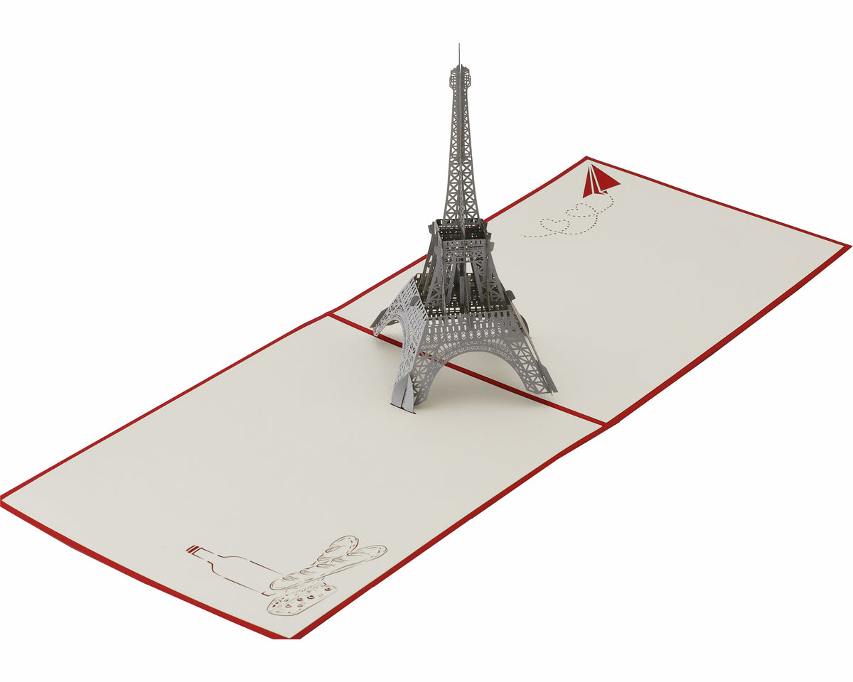 Aufgeklappte Pop-up-Karte mit Eiffelturm aus Papier, von schräg oben fotografiert.