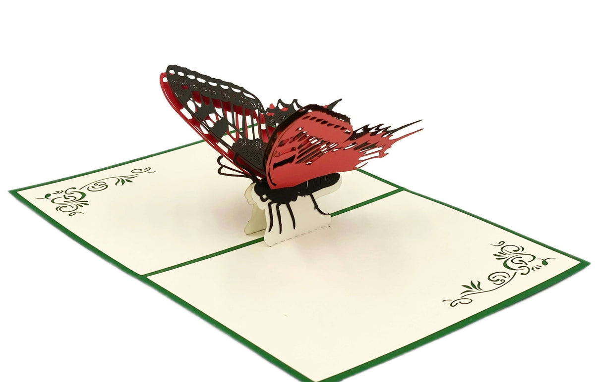 Aufgeklappte Pop-up-Karte mit einem rot-schwarzen Schmetterling, schräg von der Seite fotografiert.