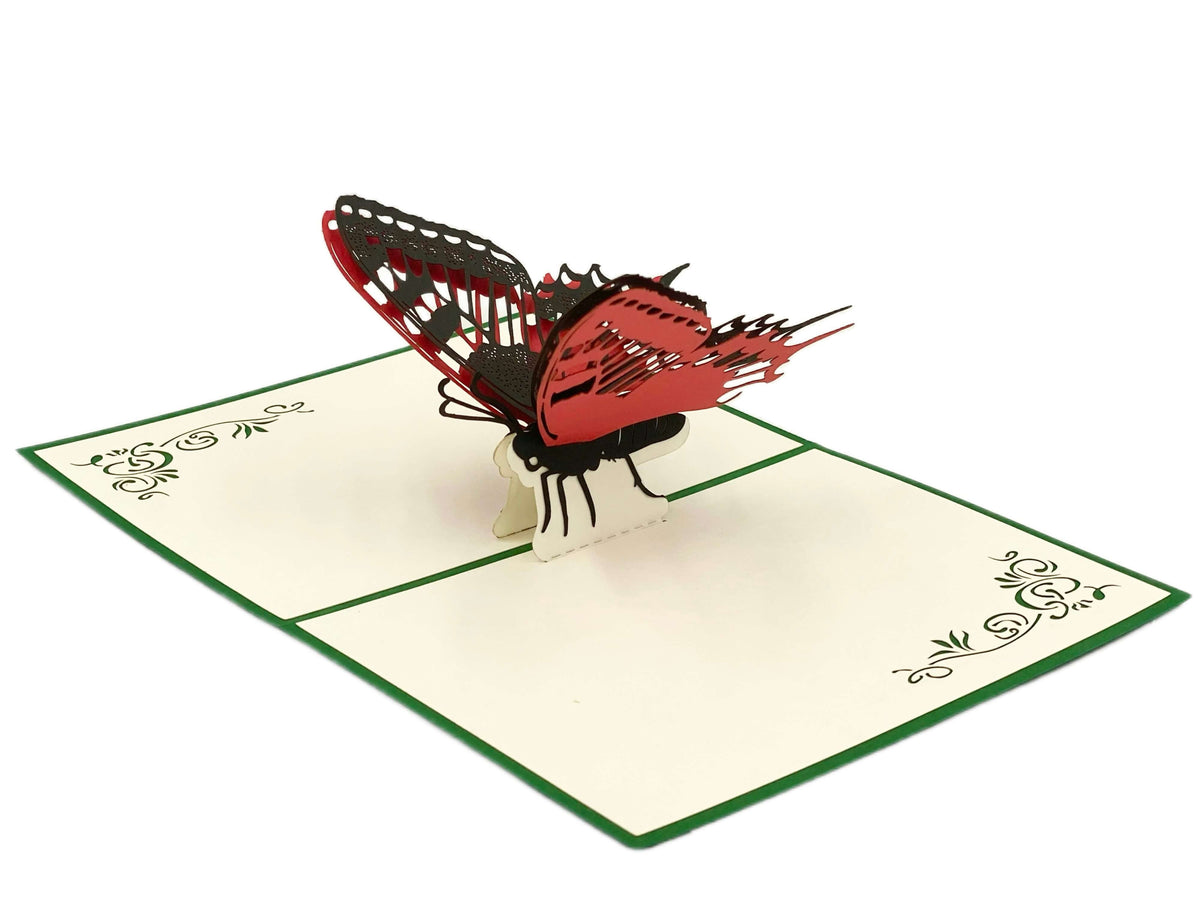 Aufgeklappte Pop-up-Karte mit einem rot-schwarzen Schmetterling, schräg von der Seite fotografiert.
