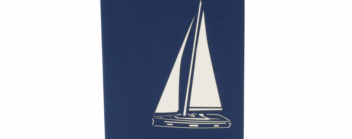 Klappkarte in blau mit einem Segelboot als Scherenschnitt.