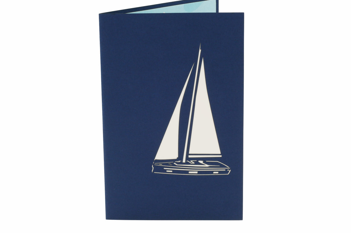 Klappkarte in blau mit einem Segelboot als Scherenschnitt.
