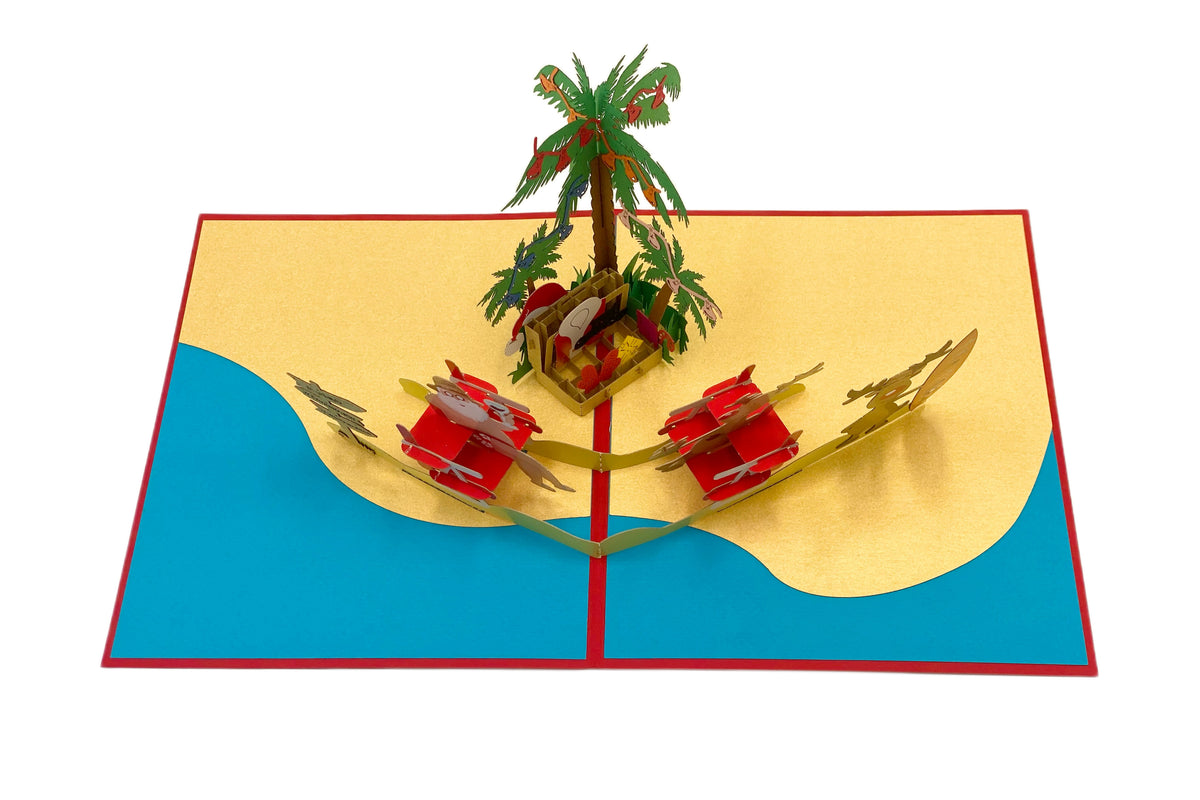 Aufgeklappte Pop-up-Karte von oben: Strandszene mit Palme, Weihnachtsmann und Rentieren auf gelbem Sand vor türkisem Meer.