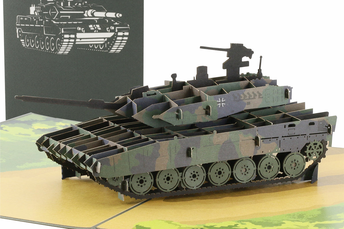 Aufgeklappte Pop-up-Karte mit einem Panzer in Tarnfarben, dahinter die grüne Kartenvorderseite mit Panzer-Scherenschnitt.