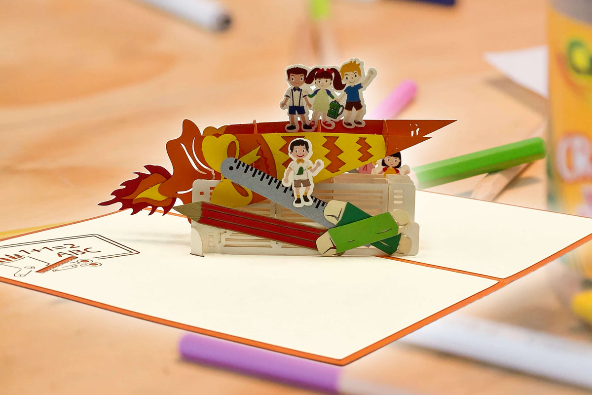 pop up karte mit schulkindern auf einer schultuete auf einem schreibtisch