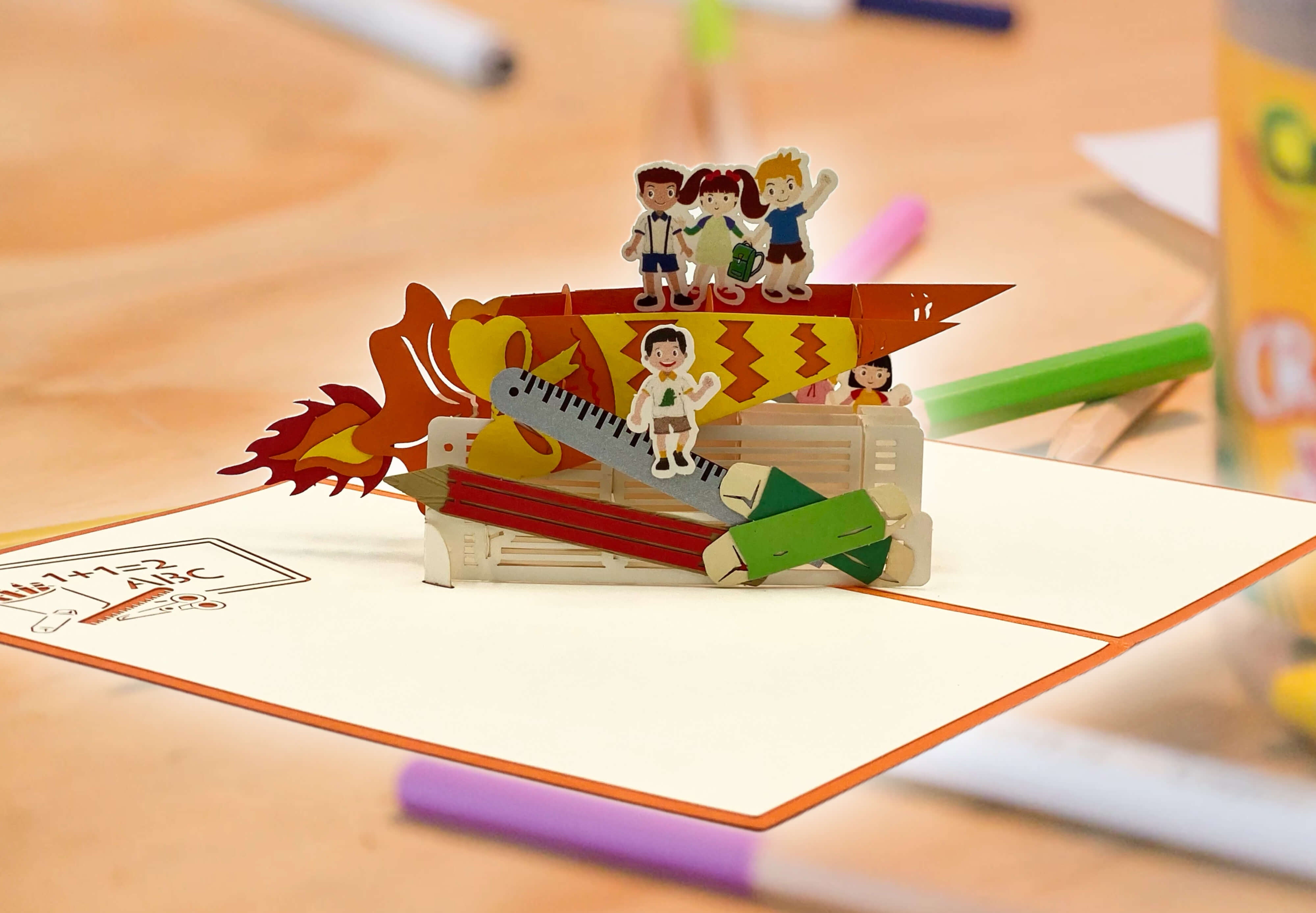 pop up karte mit schulkindern auf einer schultuete auf einem schreibtisch