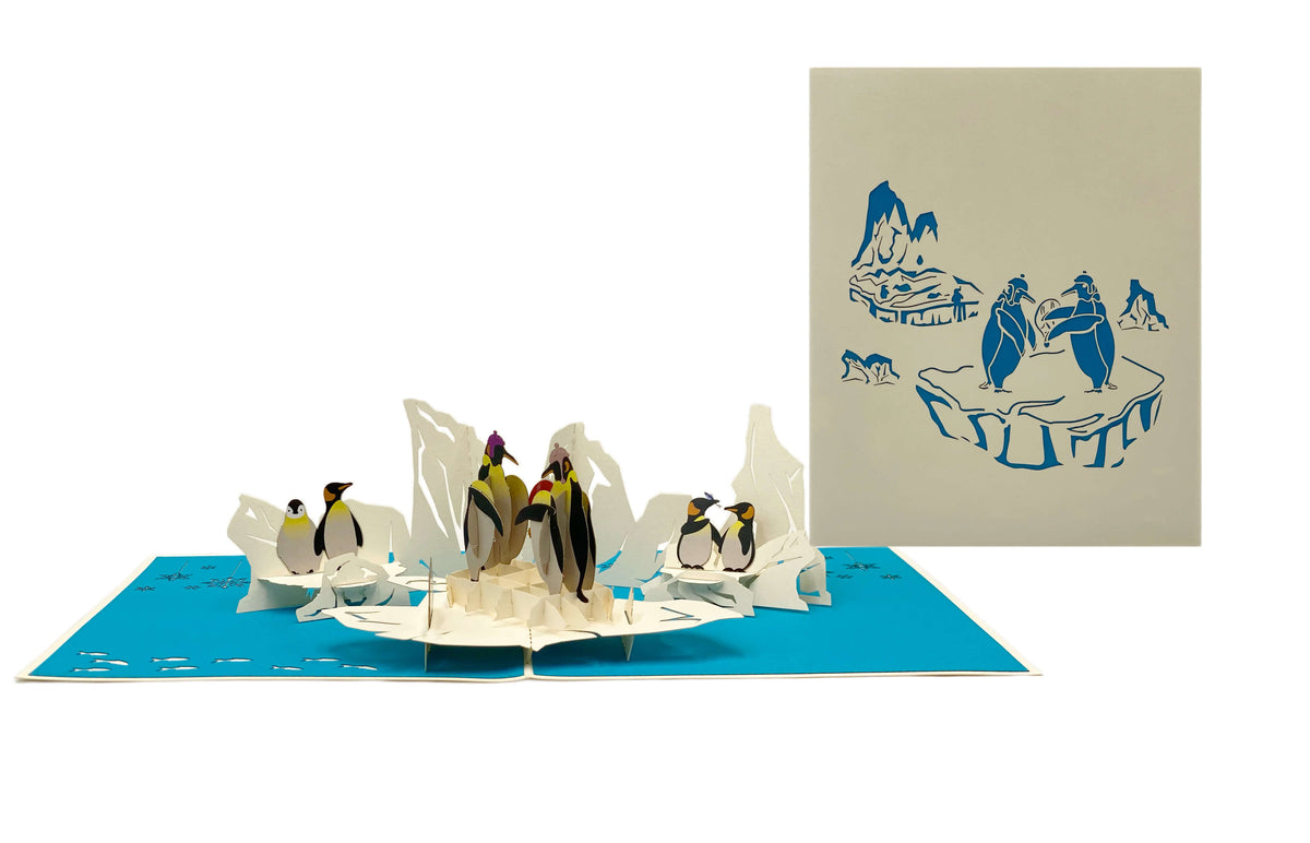 Aufgeklappte Pop-up-Karte mit Pinguinen, daneben die helle Kartenvorderseite mit Pinguin-Motiv.