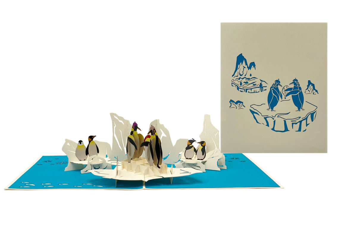 Aufgeklappte Pop-up-Karte mit Pinguinen, daneben die helle Kartenvorderseite mit Pinguin-Motiv.