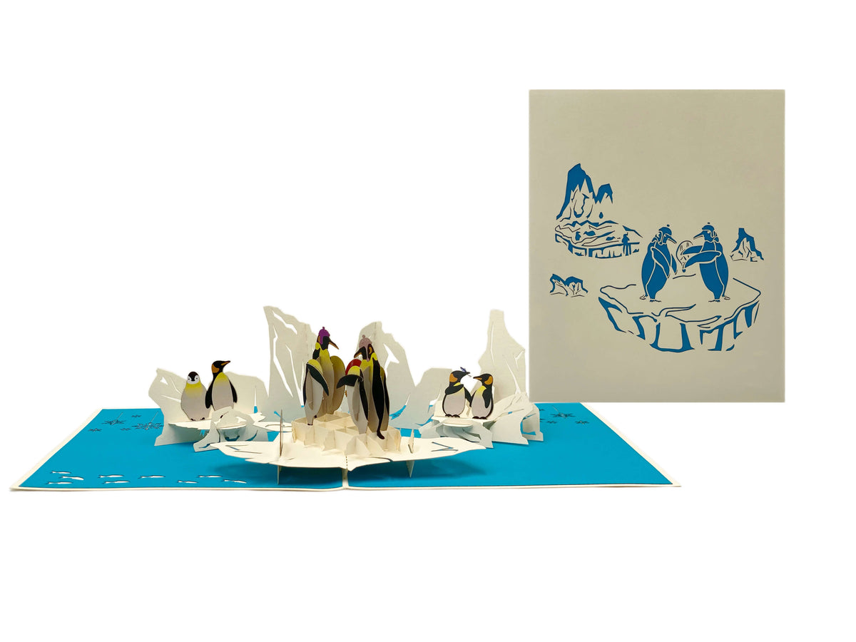 Aufgeklappte Pop-up-Karte mit Pinguinen, daneben die helle Kartenvorderseite mit Pinguin-Motiv.