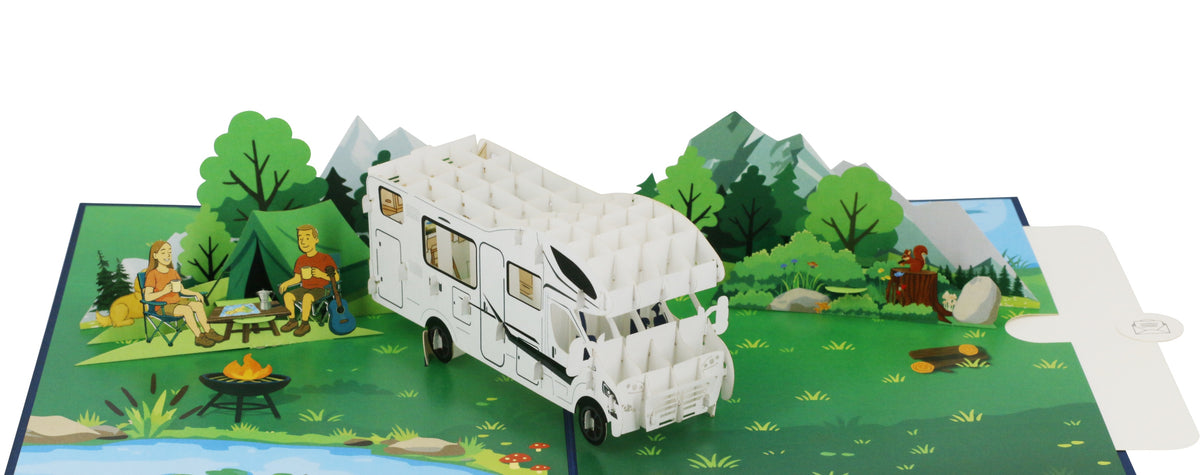 Aufgeklappte Pop-up-Karte mit Wohnmobil und Campingszene, von schräg oben fotografiert.