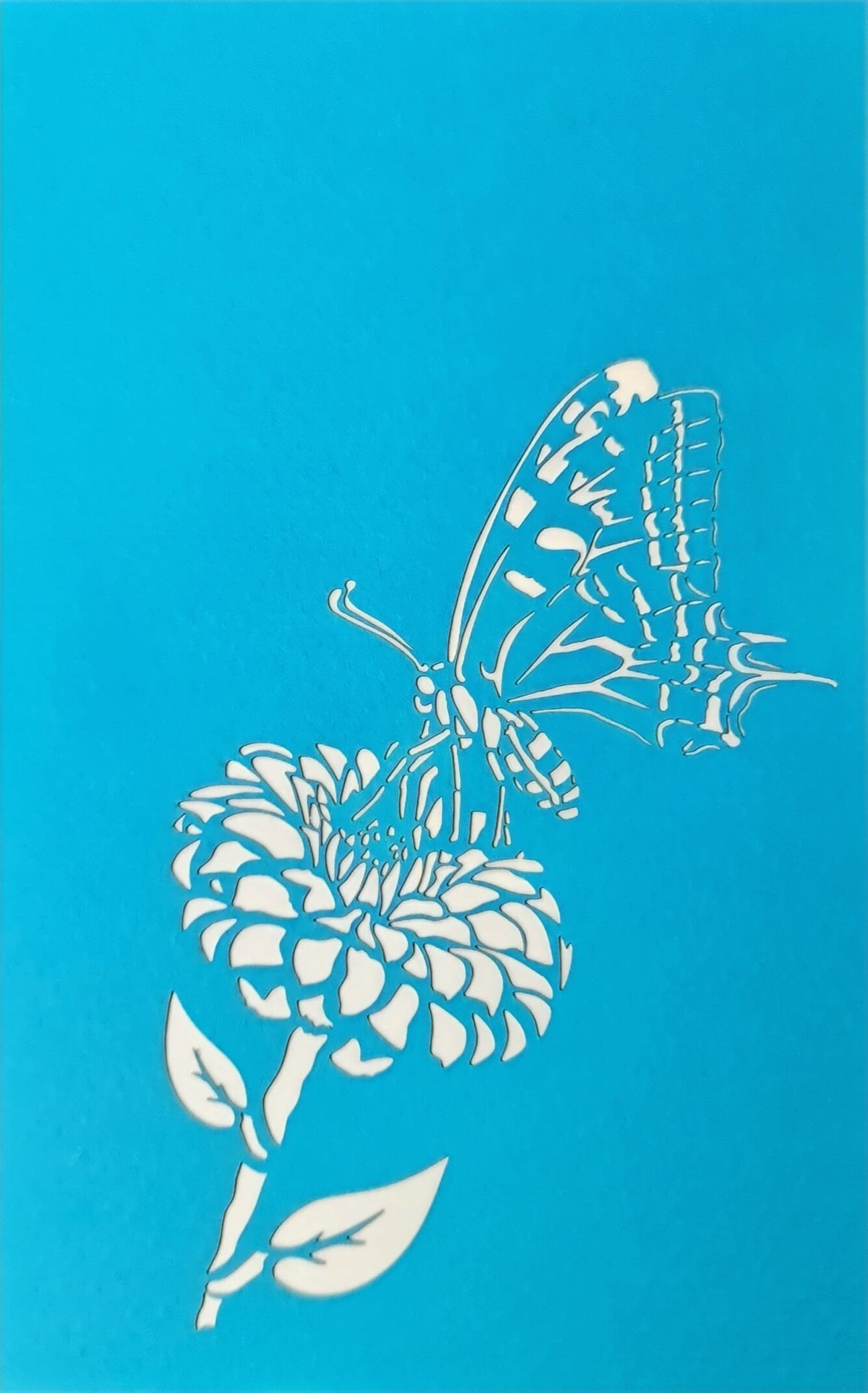 blaue karte mit einem schmetterling, der auf einer blume landet