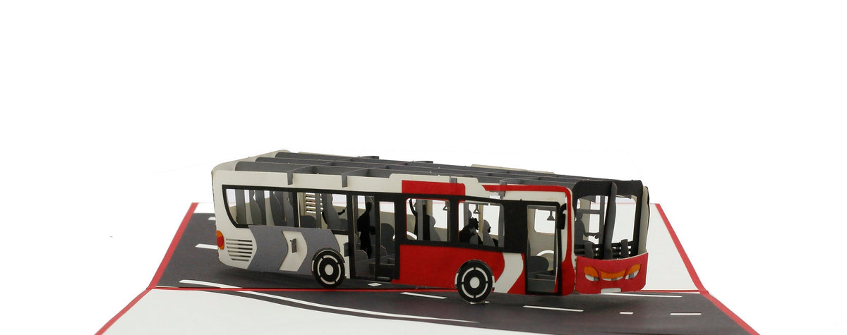 Aufgeklappte Pop-up-Karte mit rotem Rand und einem rot-weißen Gelenkbus auf einer Straße.