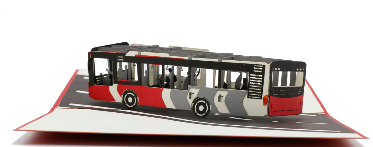 Aufgeklappte Pop-up-Karte mit rot-weißem Bus aus Papier, frontal von der Seite fotografiert.