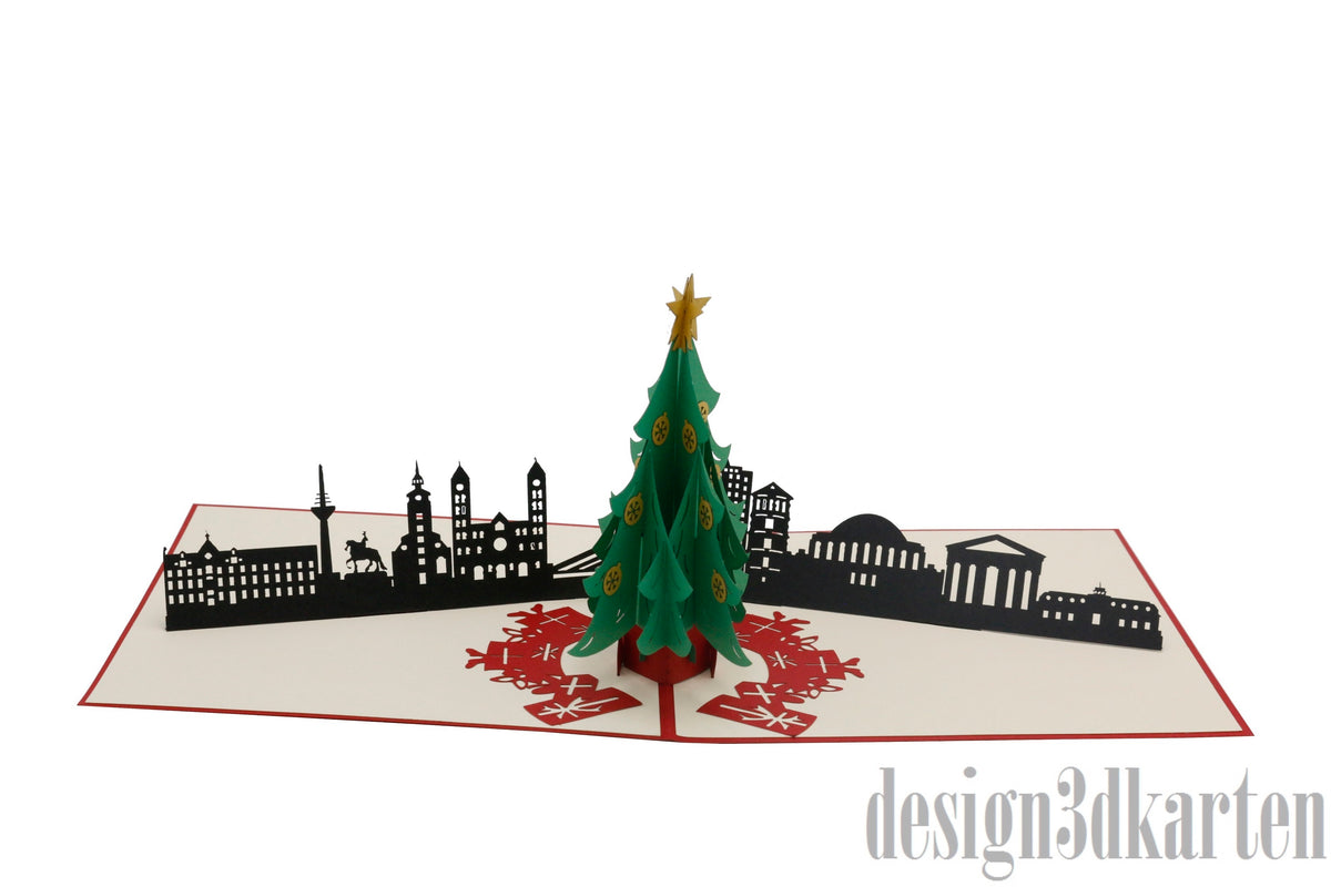 Aufgeklappte Pop-up-Karte mit grünem Weihnachtsbaum vor der Skyline von Düsseldorf.