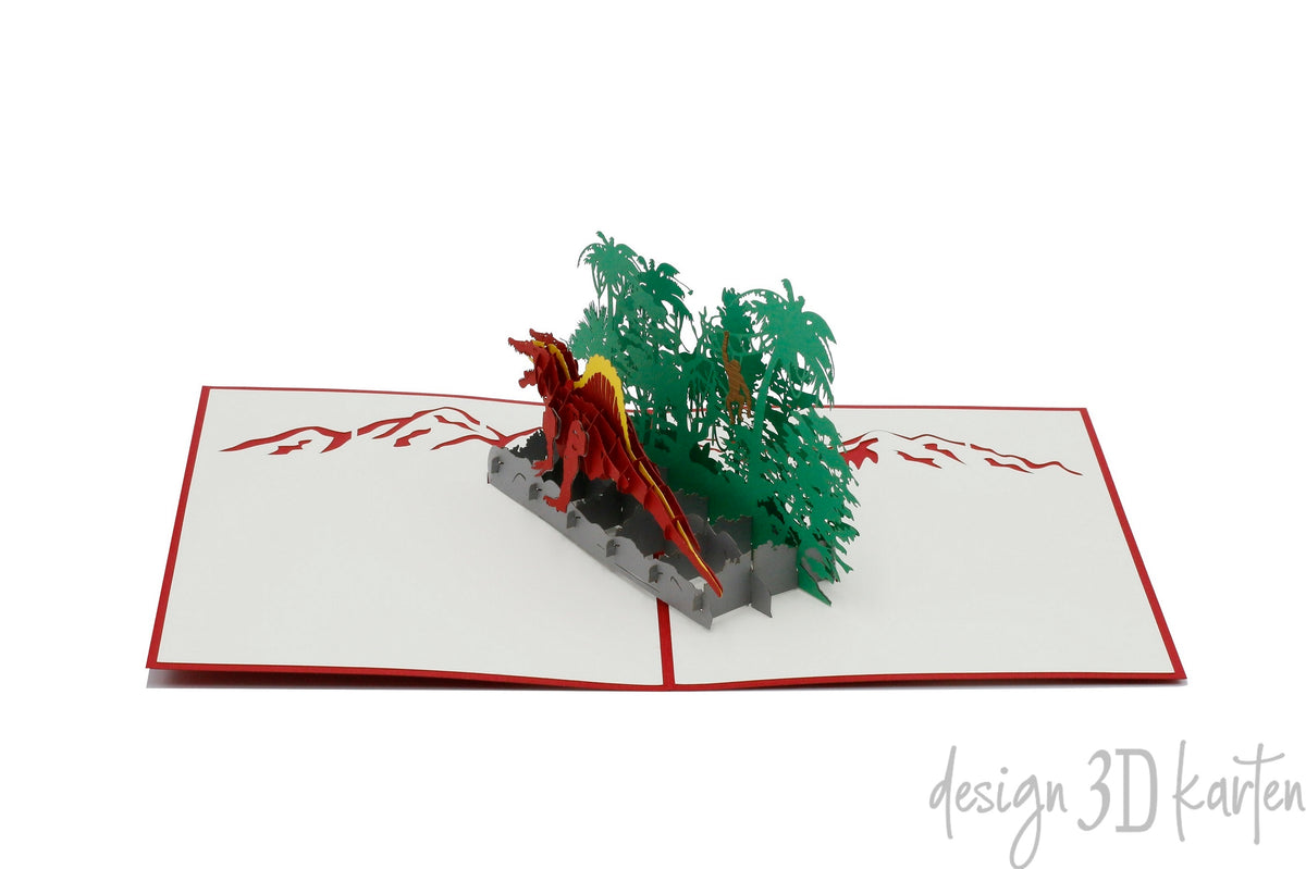Aufgeklappte Pop-up-Karte mit Dinosaurier und Dschungel, frontal fotografiert.