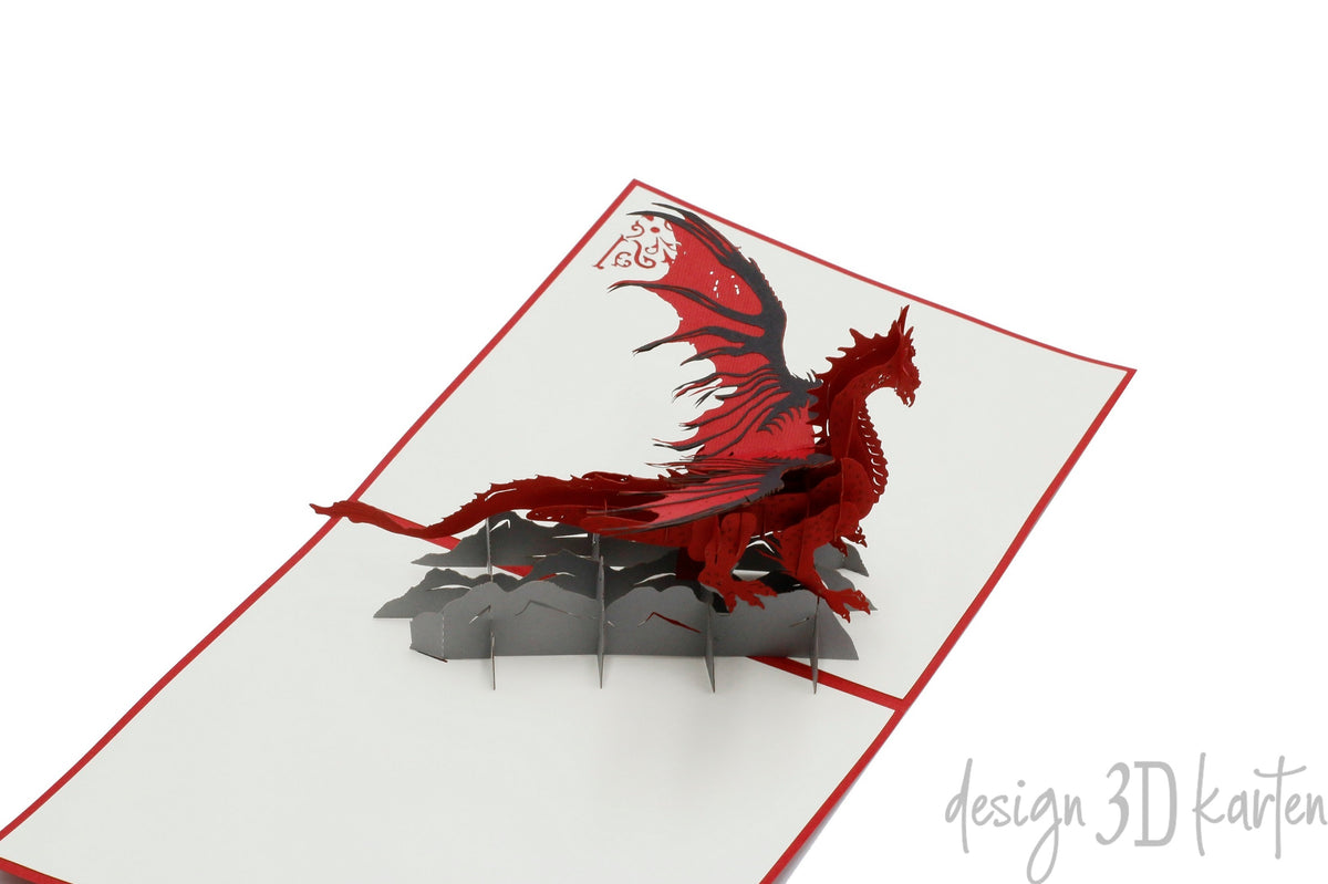 Aufgeklappte Pop-up-Karte mit rotem Drachen aus Papier, von schräg oben fotografiert.