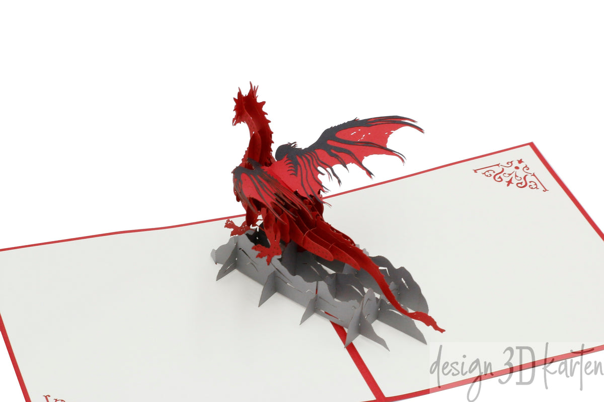 Aufgeklappte Pop-up-Karte mit einem roten Drachen mit ausgebreiteten Flügeln, frontal fotografiert.