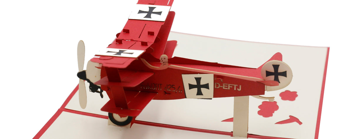 Nahaufnahme der aufgeklappten Pop-up-Karte mit einem roten Dreidecker mit Propeller und Eisernen Kreuzen.