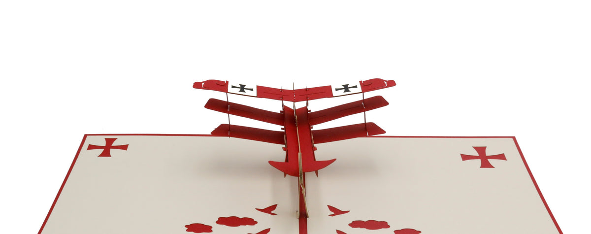 Aufgeklappte Pop-up-Karte mit rotem Flugzeug aus Papier, frontal von vorne fotografiert.