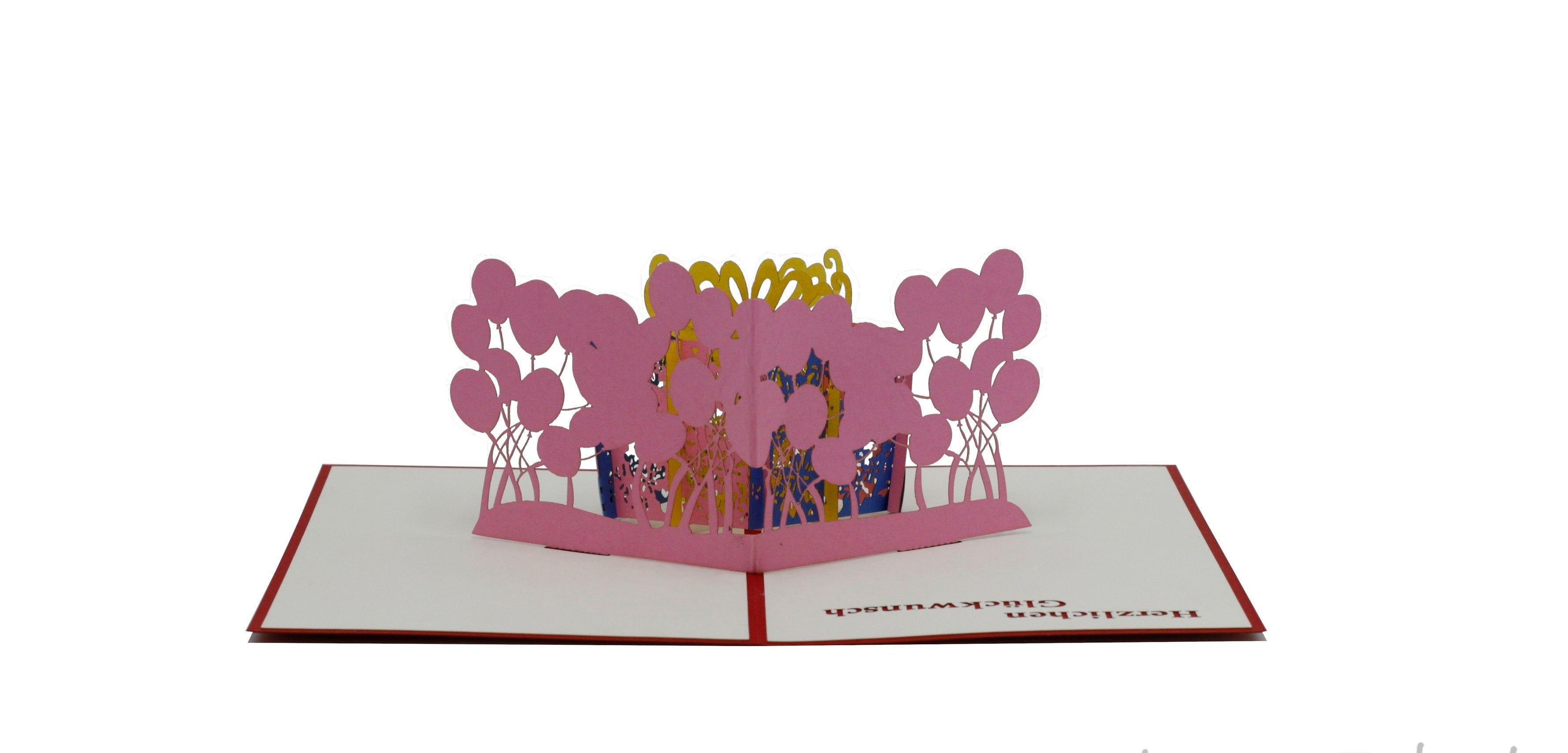 Aufgeklappte Pop-up-Karte mit rosa Geschenkbox und Luftballons, frontal fotografiert.