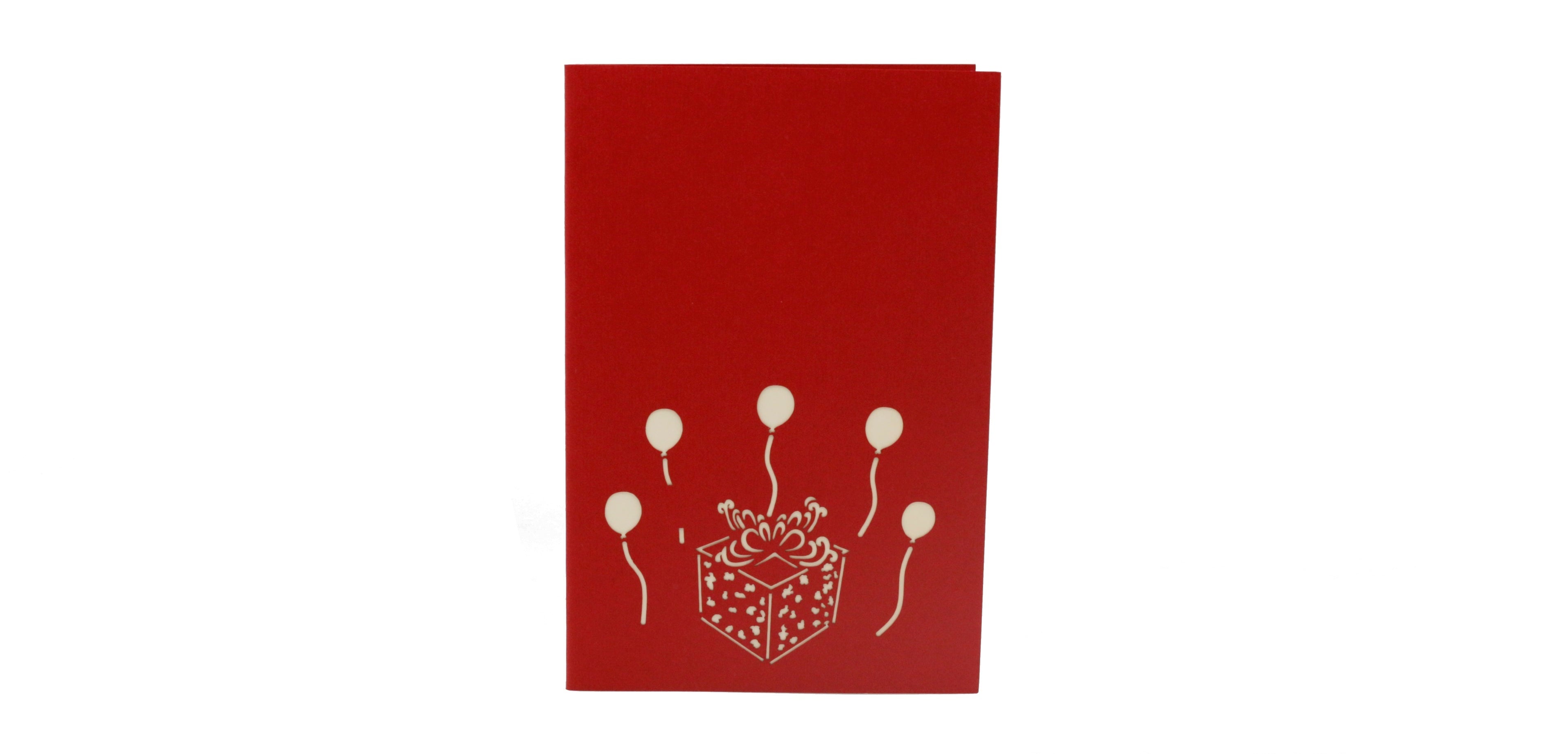 Rote Kartenvorderseite mit einem Geschenkpaket und Luftballons als Scherenschnitt.