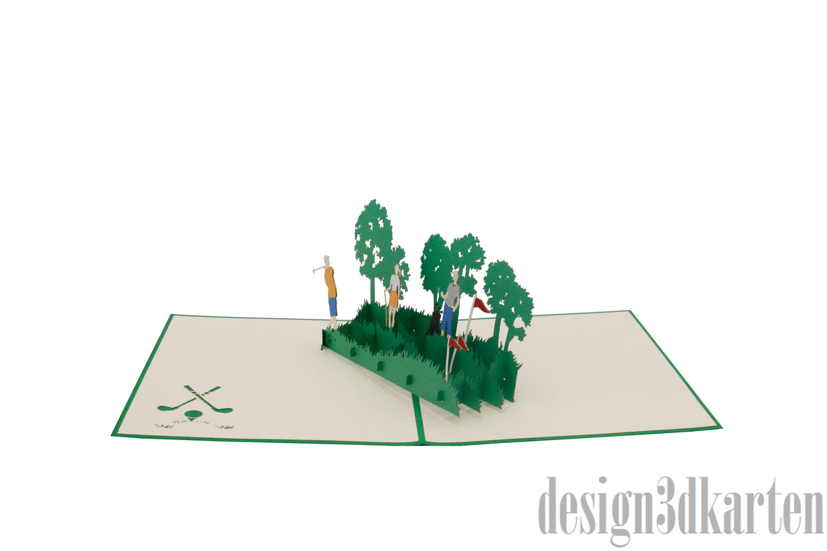 Aufgeklappte Pop-up-Karte mit einer Golfszene aus Papier, schräg von der Seite fotografiert.