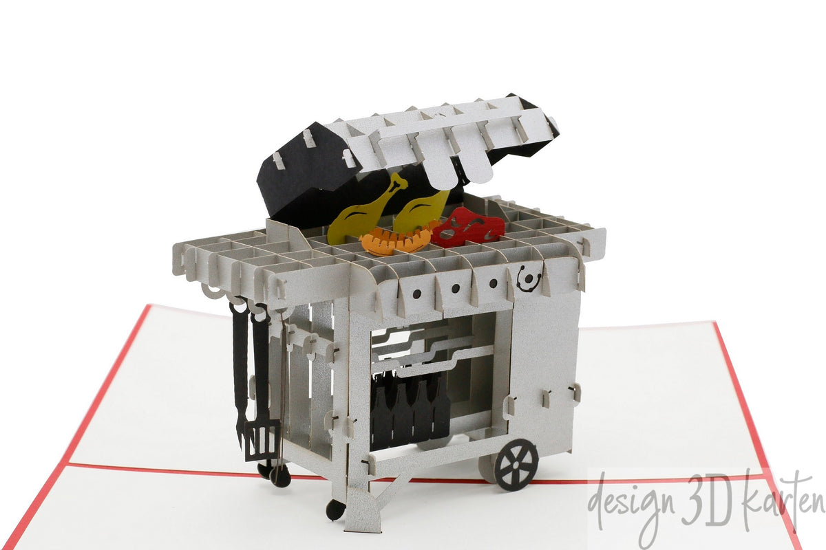 Nahaufnahme der aufgeklappten Pop-up-Karte mit einem Gasgrill aus Papier, auf dem Rost liegen Würstchen und Gemüse.