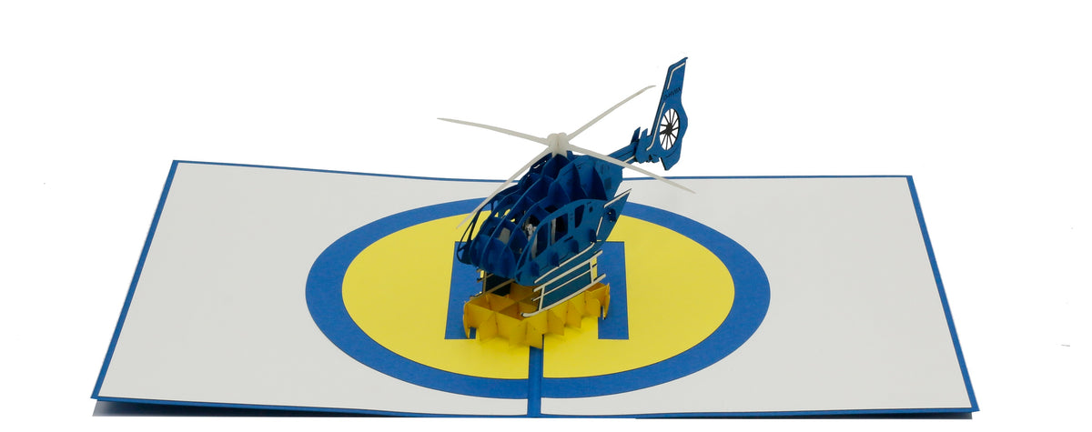 Aufgeklappte Pop-up-Karte mit Hubschrauber und Landeplatz, frontal fotografiert.