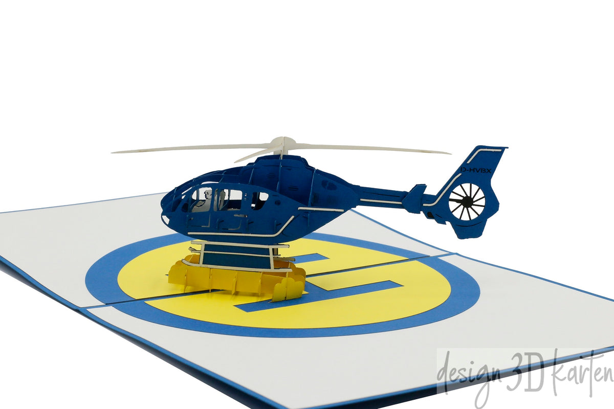 Nahaufnahme der aufgeklappten Pop-up-Karte mit einem blauen Hubschrauber aus Papier.
