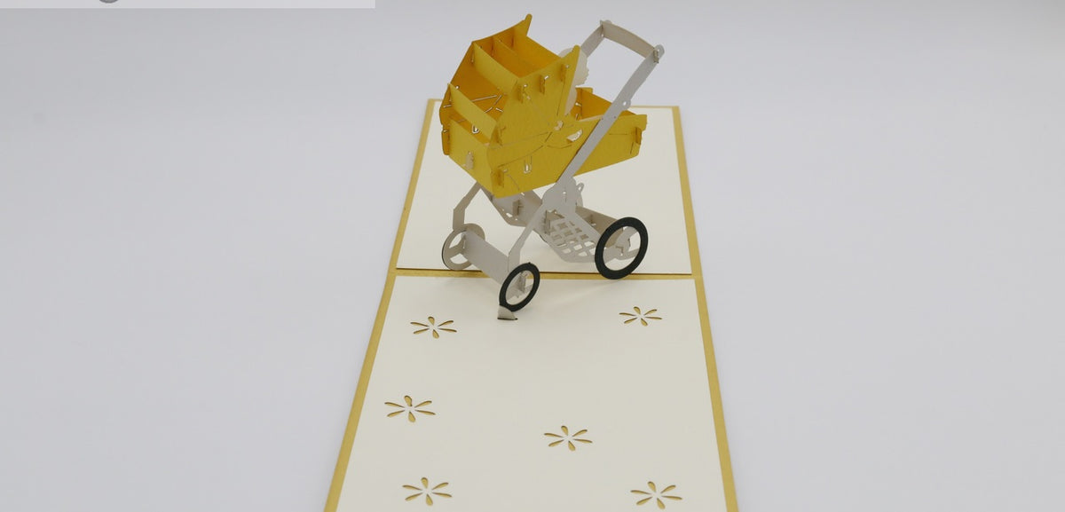 Aufgeklappte Pop-up-Karte mit gelbem Rand und einem gelben Kinderwagen aus Papier.