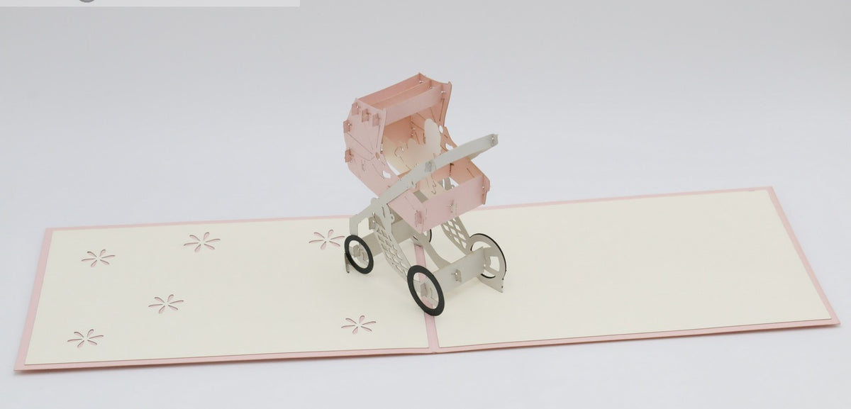 Aufgeklappte Pop-up-Karte mit rosa Rand und einem rosa Kinderwagen aus Papier.