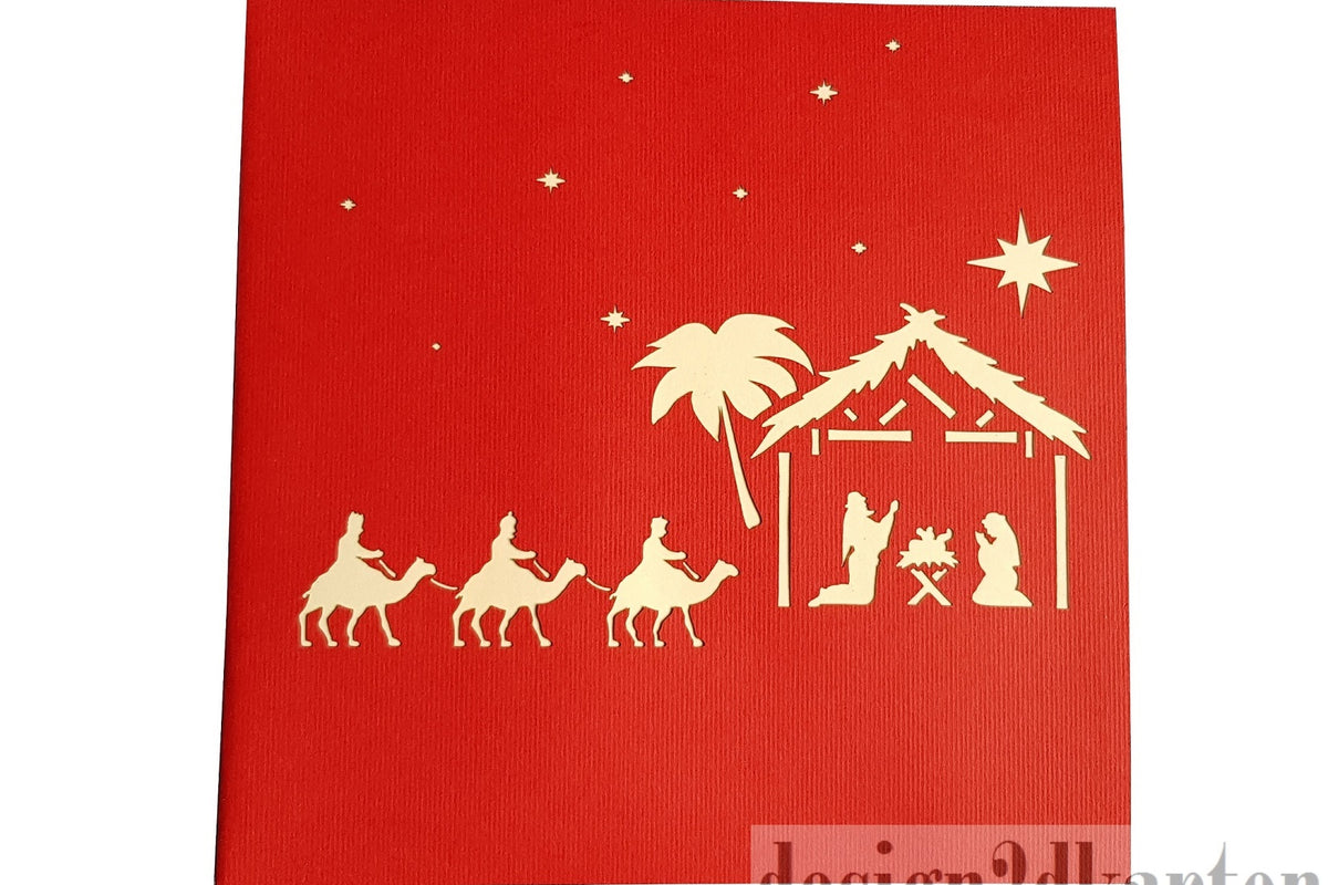 Rote Kartenvorderseite mit Weihnachtskrippe, den Heiligen Drei Königen auf Kamelen und dem Stern als Scherenschnitt.