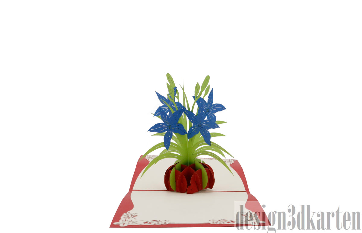 Aufgeklappte Pop-up-Karte mit rotem Rand und einem Strauß blauer Lilien in einer roten Vase.