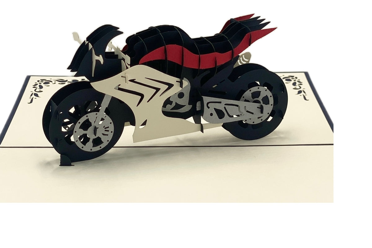 Nahaufnahme der aufgeklappten Pop-up-Karte mit einer weiß-schwarz-roten Rennmaschine aus Papier.