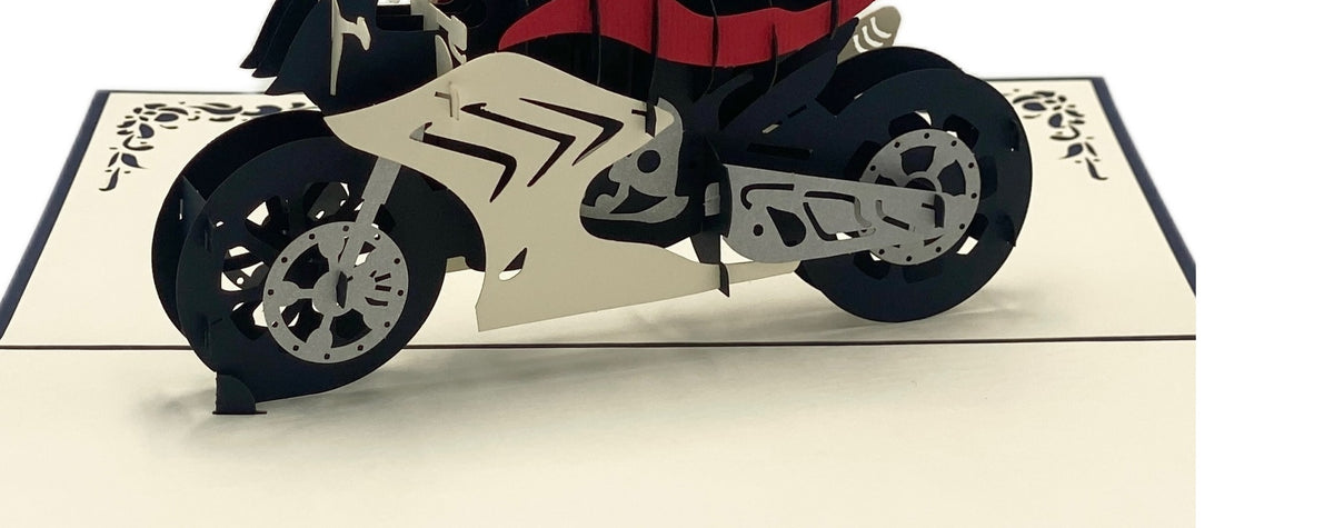 Nahaufnahme der aufgeklappten Pop-up-Karte mit einer weiß-schwarz-roten Rennmaschine aus Papier.