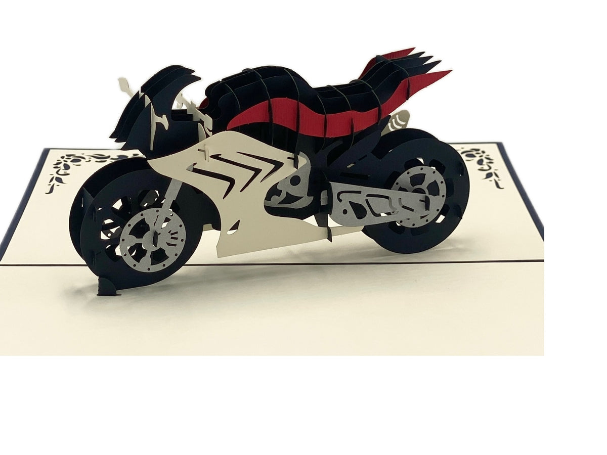 Nahaufnahme der aufgeklappten Pop-up-Karte mit einer weiß-schwarz-roten Rennmaschine aus Papier.
