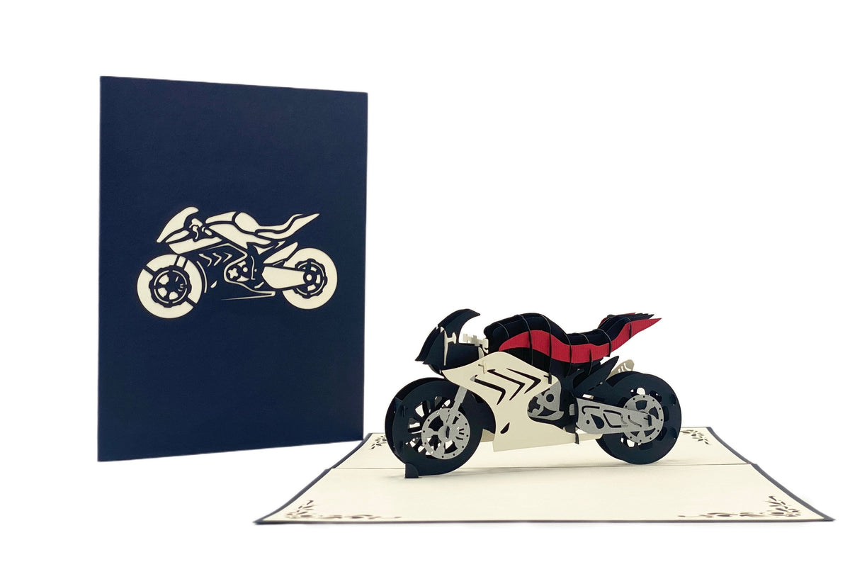 Aufgeklappte Pop-up-Karte mit Rennmaschine, daneben die dunkelblaue Kartenvorderseite mit Motorrad-Scherenschnitt.
